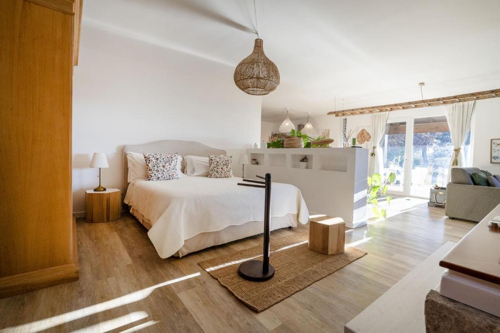 ein weißes Schlafzimmer mit einem Bett und ein Wohnzimmer in der Unterkunft Suite in Villa Torto with pool in Monopoli
