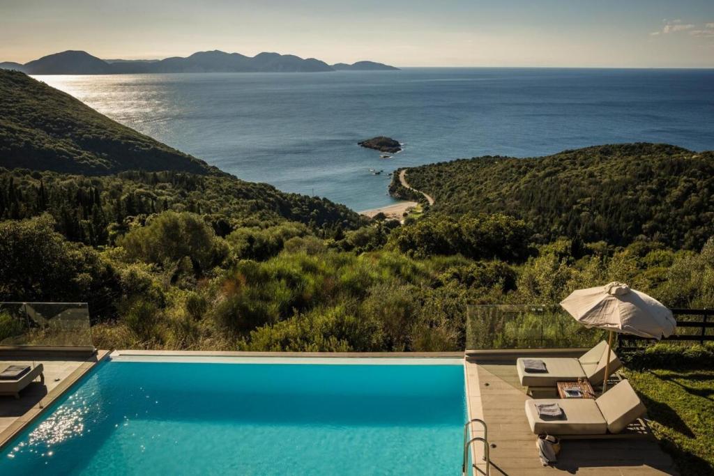 a swimming pool with a view of the ocean at Entheos Private Villa Fiskardo Kefalonia Greece in Fiskardho