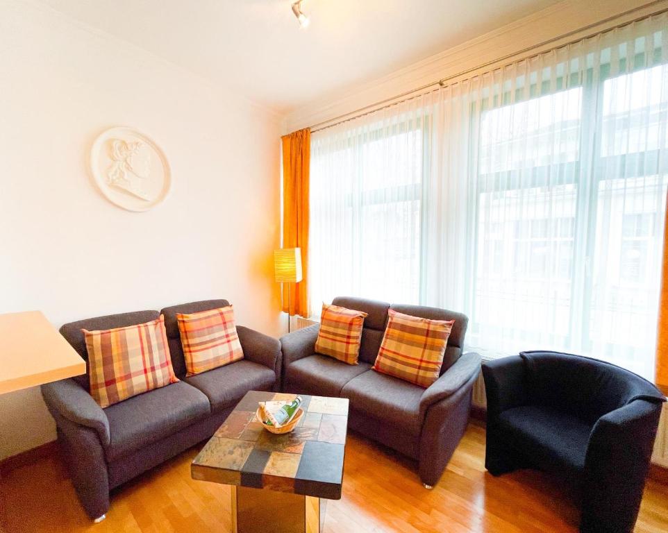 una sala de estar con un sofá y una mesa en Villa Perkunos Wohnung Nr. 6, en Heringsdorf