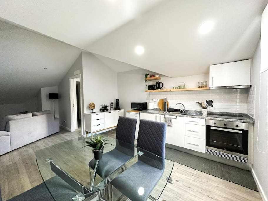 a kitchen with white cabinets and chairs in a room at Pena Apartments C in Funchal