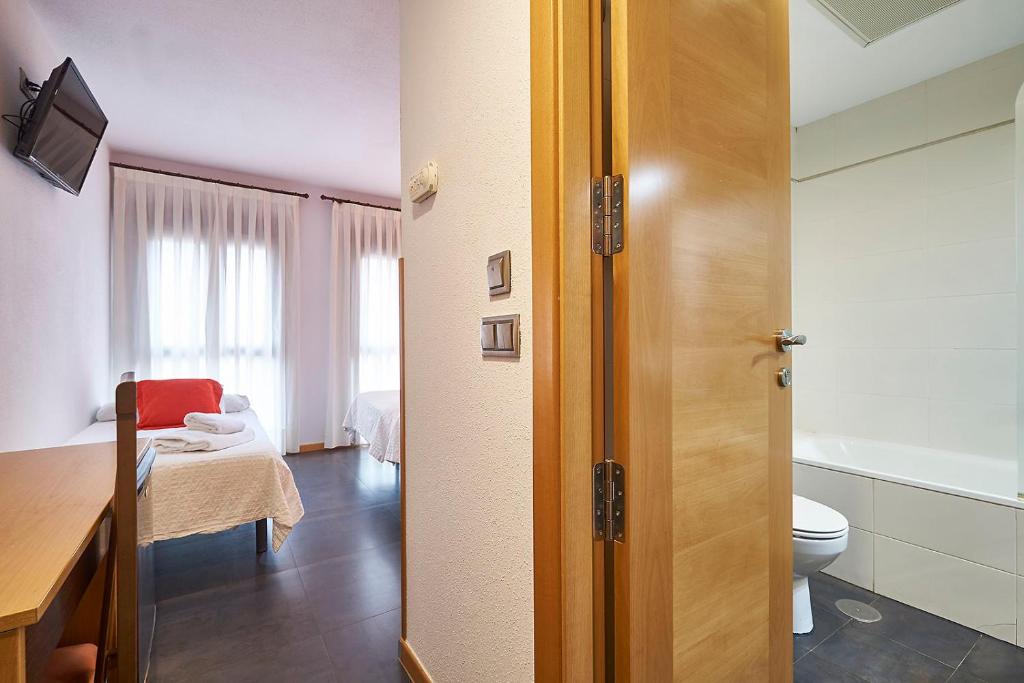 a room with a bathroom with a toilet and a sink at Hotel Real de Illescas in Illescas