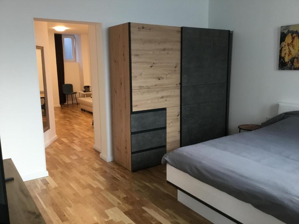 ein Schlafzimmer mit einem Bett und einer Holzkommode in der Unterkunft Sieveringer A-B in Wien