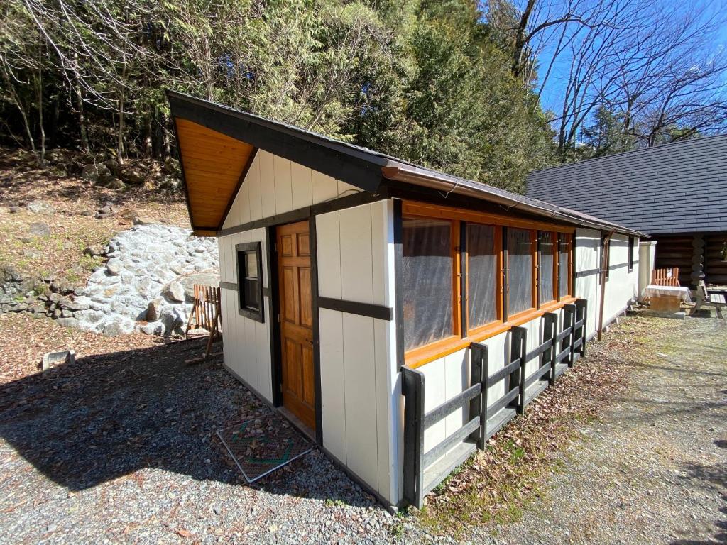 ein kleines weißes und braunes Gebäude mit einer Tür in der Unterkunft West River Auto Campground - Vacation STAY 81835v 