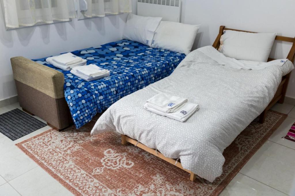 a bedroom with a bed and a couch with towels on it at Stavroula's Houses in Kélla