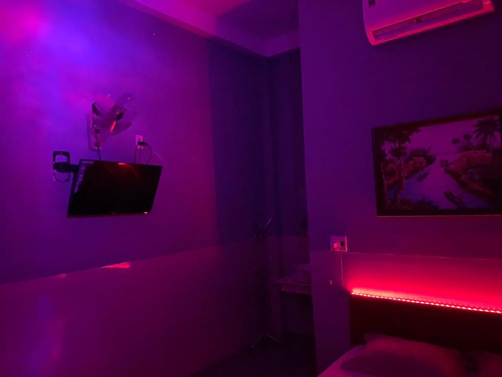 um quarto roxo com uma cama com luz vermelha em Khách sạn minion 2 em Thuan An