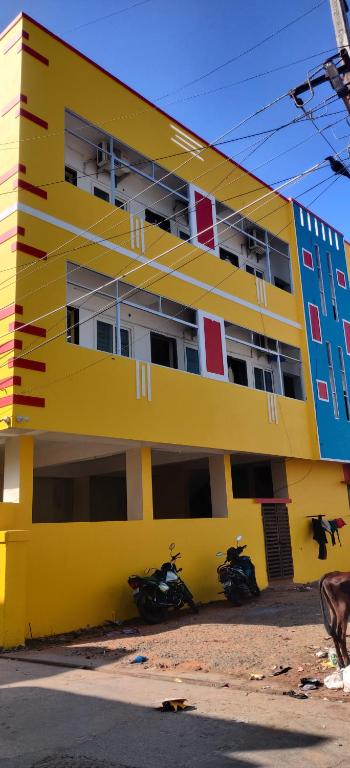 蓬蒂切里‌‌Florence guest house的停在前面的黄色建筑,有摩托车