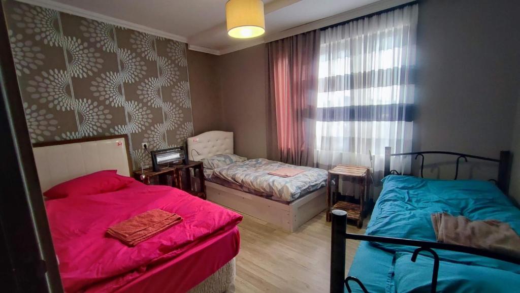 a bedroom with two beds and a window at The Friends in Kutaisi