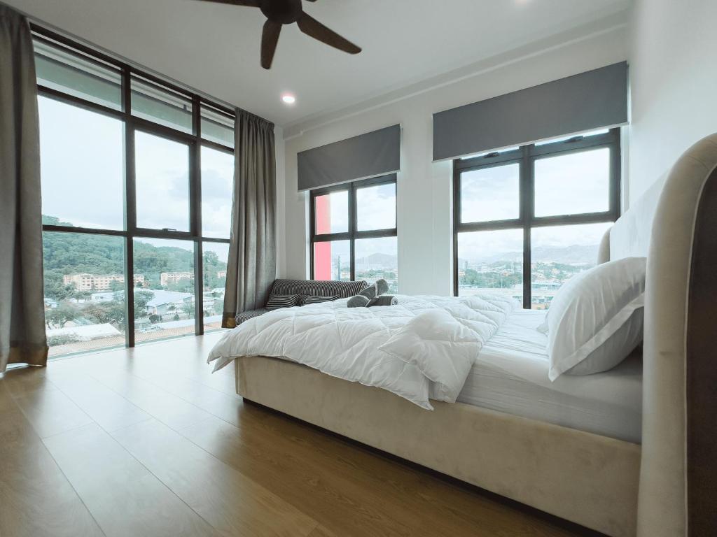 um quarto com uma cama com lençóis brancos e janelas em Duplex w indoor private pool - 12 pax - Ampang Jaya em Ampang