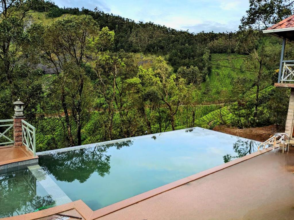 een zwembad met uitzicht op een berg bij The Planet Munnar in Suryanelli