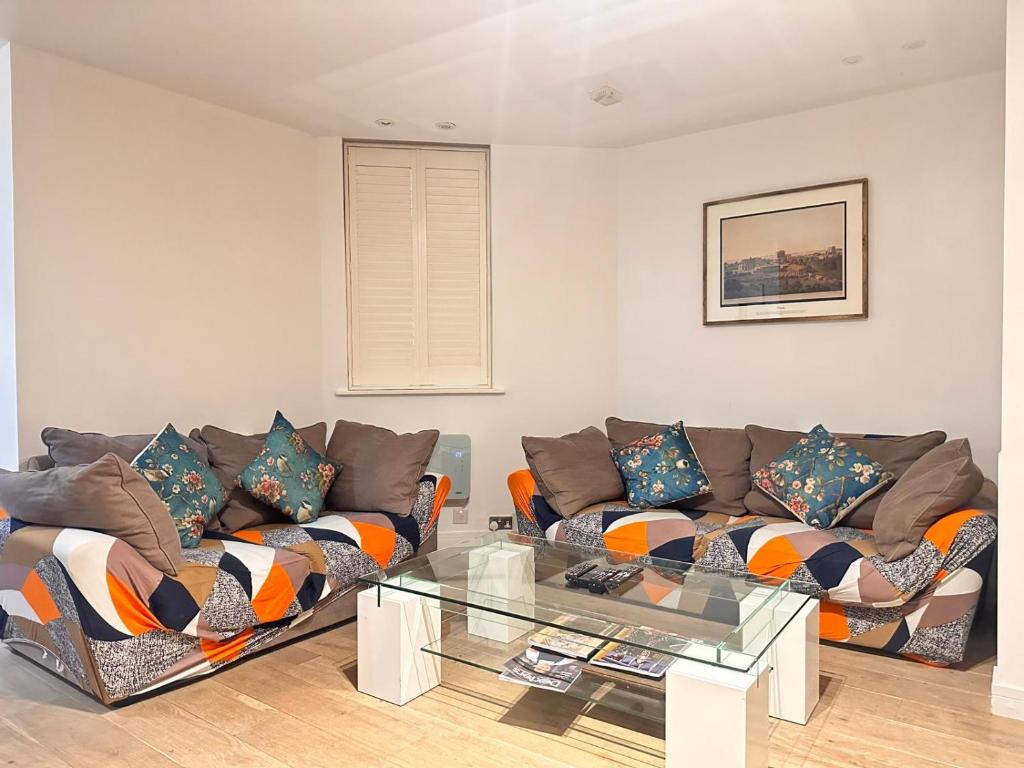 a living room with two couches and a glass table at Spacious Central London flat - 2BHK in London
