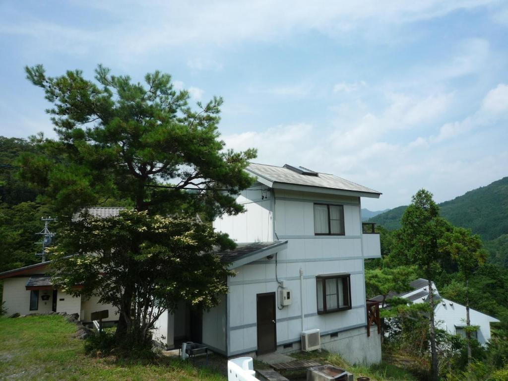 Biały dom na wzgórzu z drzewem w obiekcie Ten Ten Go Shibu Kawa - Vacation STAY 41956v w mieście Ono