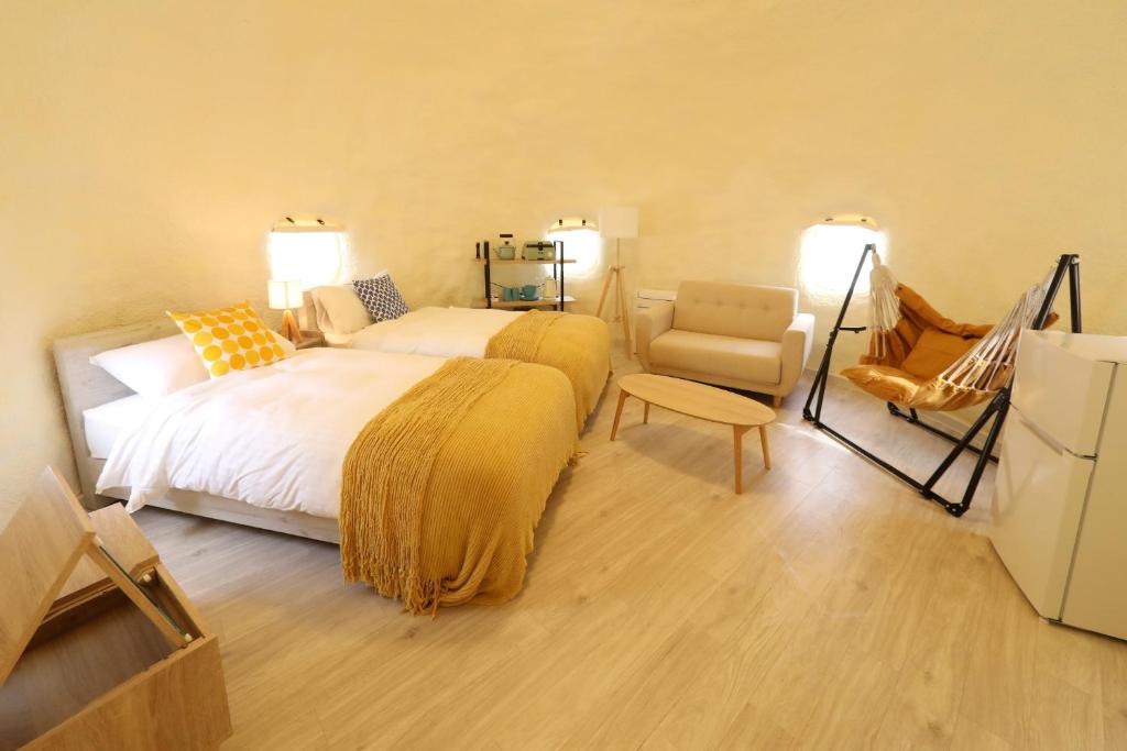 a bedroom with a large bed and a chair at ASOGUNI Glamping - Vacation STAY 42307v in Oguni