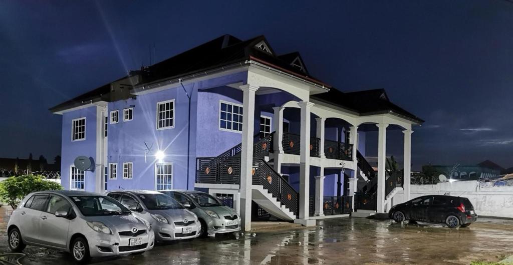 un edificio azul con coches estacionados en un estacionamiento en Beautiful 2-Bed Apartment in Accra en Accra