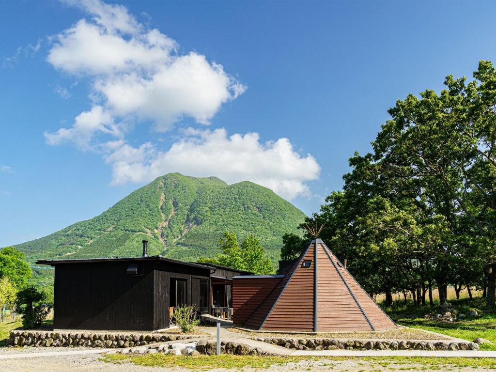 uma pequena casa com uma montanha ao fundo em Sense of wonder Yufudake Sanroku Glamping Resort - Vacation STAY 41962v em Yufu