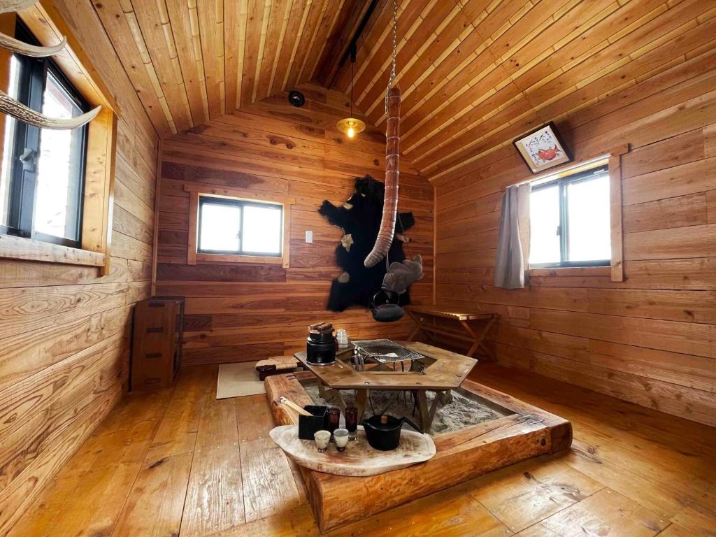 una vista interna di una cabina in legno con tavolo di Kuruma Asobi Adventure Field Appi - Camp - Vacation STAY 42160v a Hachimantai