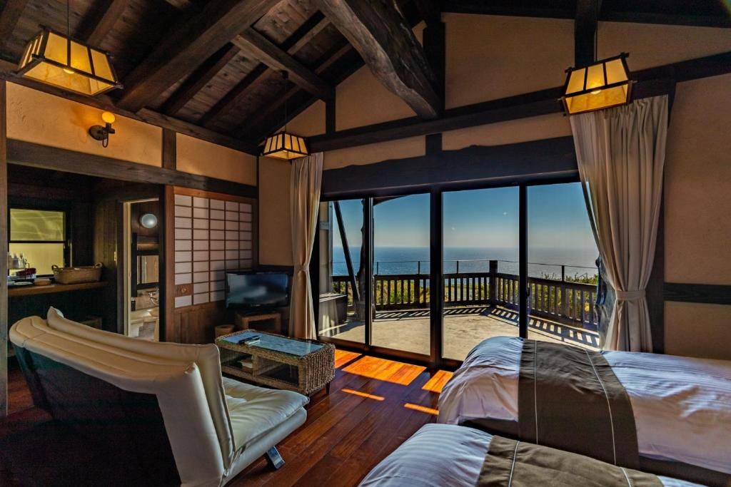 a bedroom with a balcony with a view of the ocean at Minamiizu Yuhigaoka Camp Site - Camp - Vacation STAY 42067v in Ihama