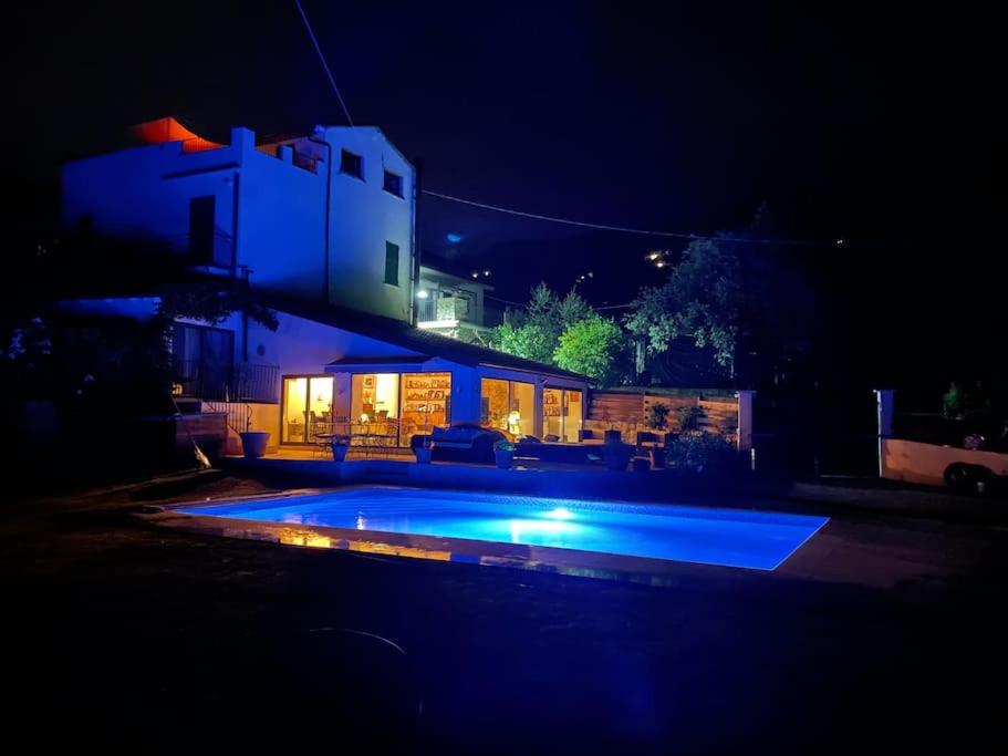 a house with a swimming pool at night at La Stala in Pieve di Teco