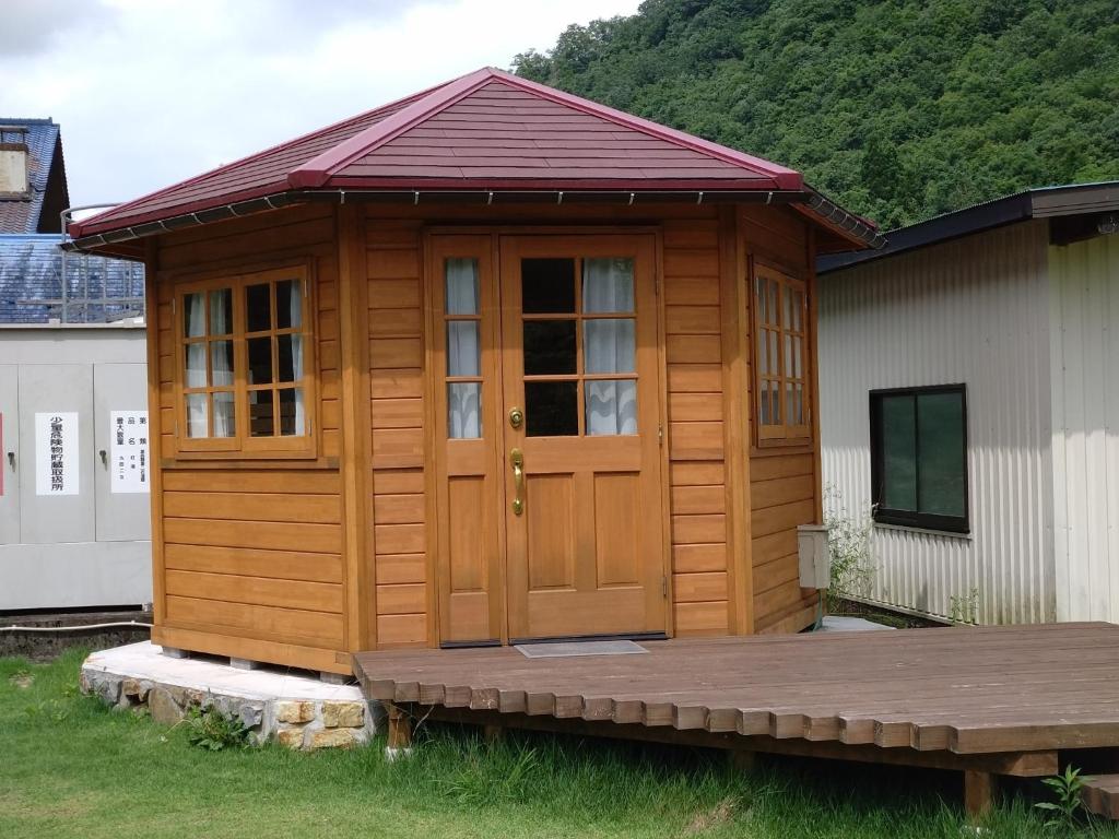 a cabin with a wooden door and a deck at Ayu no Sato Park Campsite - Vacation STAY 42154v in Shōbara