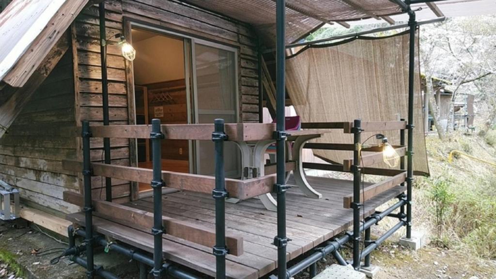 a front porch of a log cabin with a table at Ryujin Village Oku-Komatagawa Bungalow - Vacation STAY 42247v in Ōkuma