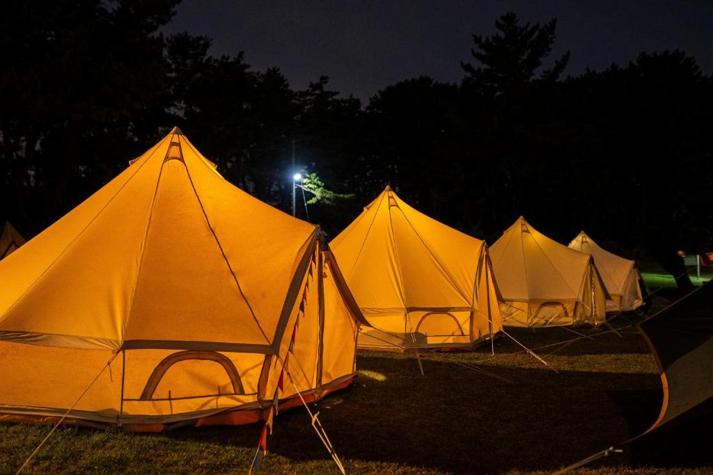 a row of tents in a field at night at Tanesashi Campsite - Camp - Vacation STAY 42215v in Hachinohe
