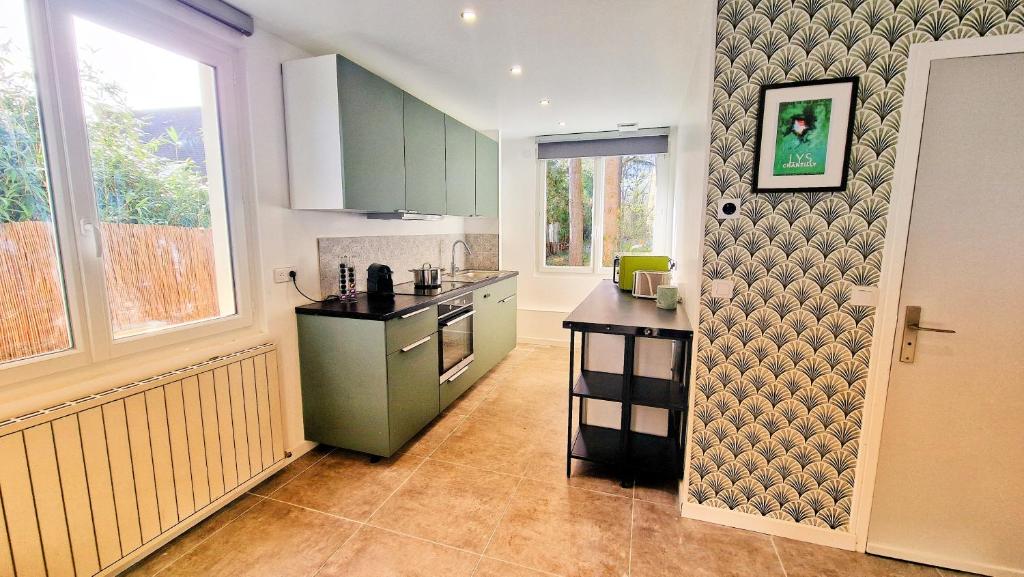 uma cozinha com armários verdes e um balcão em Maison Mayel - Logement Entier - Domaine Privé Résidentiel Chic & Nature em Lamorlaye