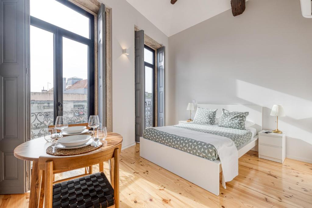 a white bedroom with a bed and a table at FindMe InPorto Bonfim in Porto