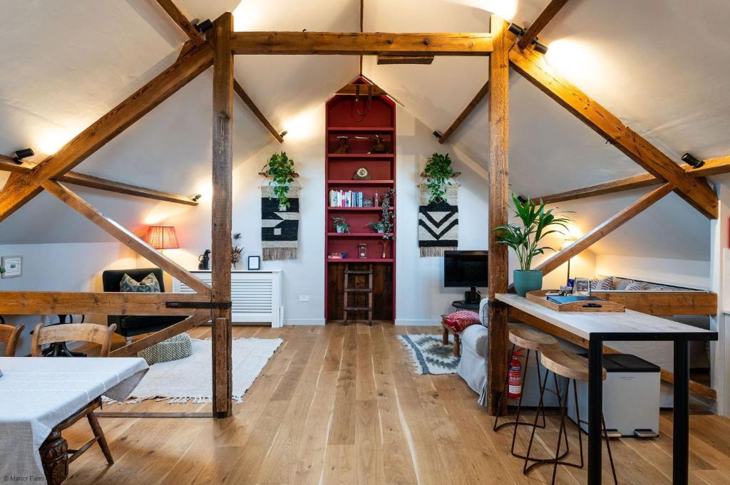 Habitación con vigas de madera y habitación con mesa. en The Garret, en Salisbury
