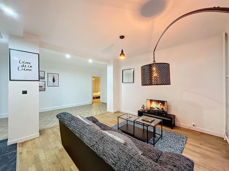 un salon avec un canapé et une cheminée dans l'établissement Cosy Appartement, Lyon 6è Barrier, à Lyon