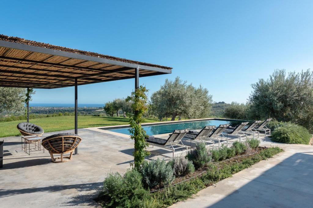 une piscine avec des chaises longues et une pergola dans l'établissement Villa Vogue - IsulaTravel, à Avola