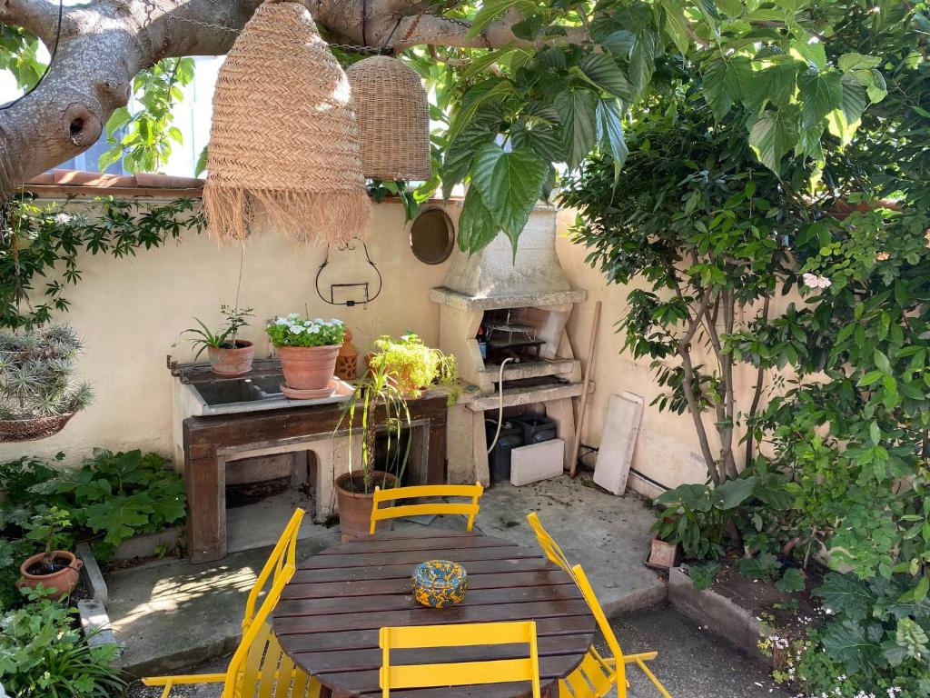 une terrasse avec une table, des chaises et une cuisinière dans l'établissement Villa quartier des fleurs 5 min Canet, à Canet