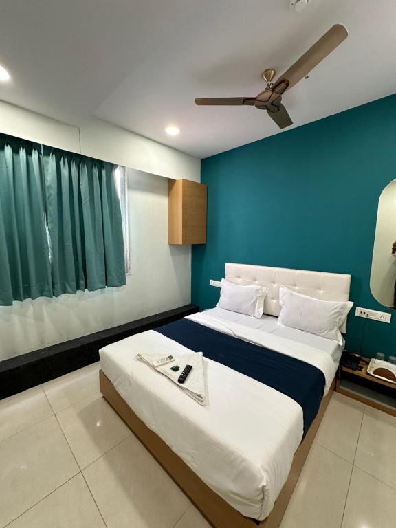 um quarto com uma cama grande e uma parede azul em Hotel sky palace adajan em Surat