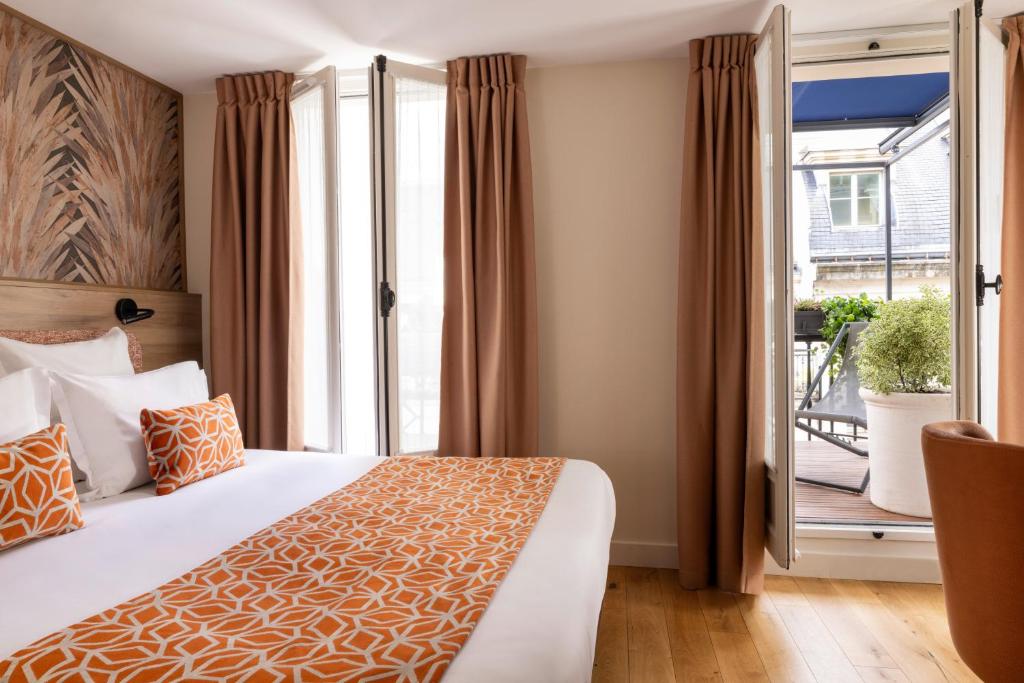 a hotel room with a bed and a balcony at Dream Hôtel Opéra & Spa in Paris