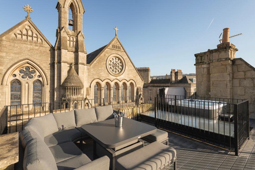 a patio with a couch and a table in front of a church at St Paul's House in Bath