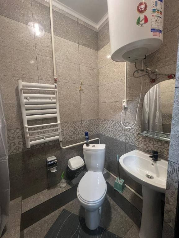 y baño con aseo y lavamanos. en Sayak hostel, en Karakol