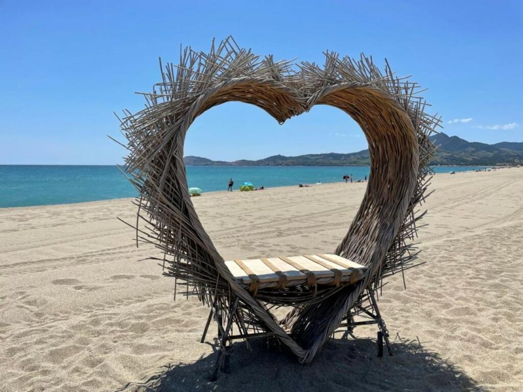 uma cadeira em forma de coração numa praia em Grand studio 4 50m de la plage pour 4 em Argelès-sur-Mer