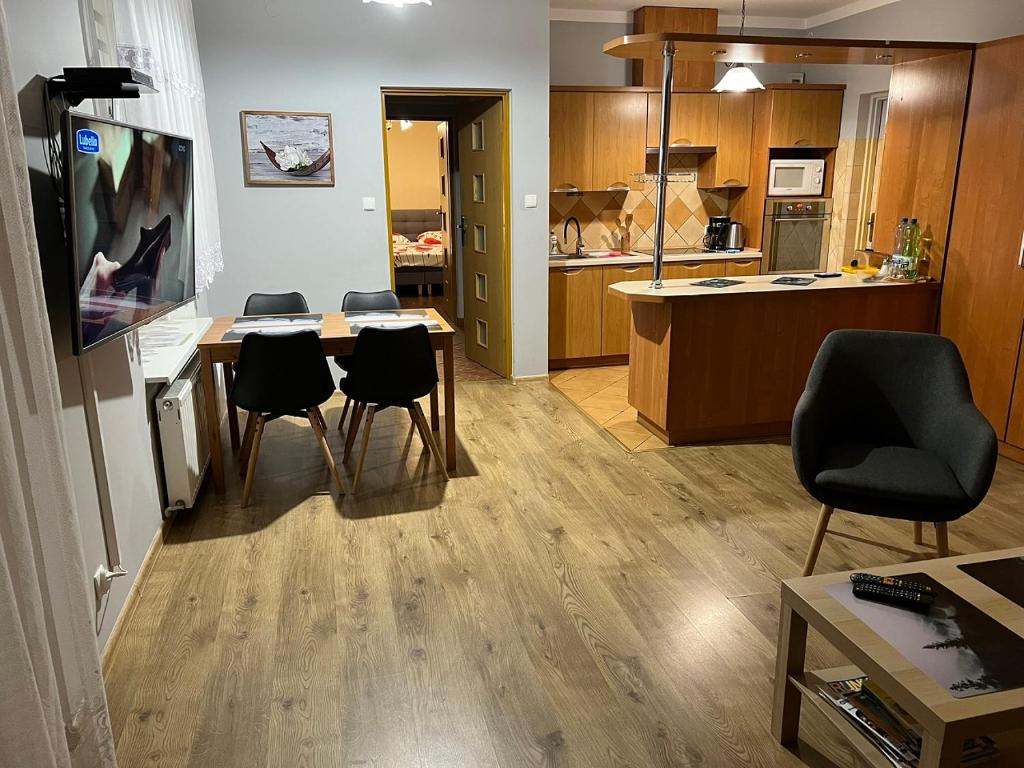 a living room with a table and chairs and a kitchen at Apartament Kudowa Zdrój - Słone 60m2 in Kudowa-Zdrój