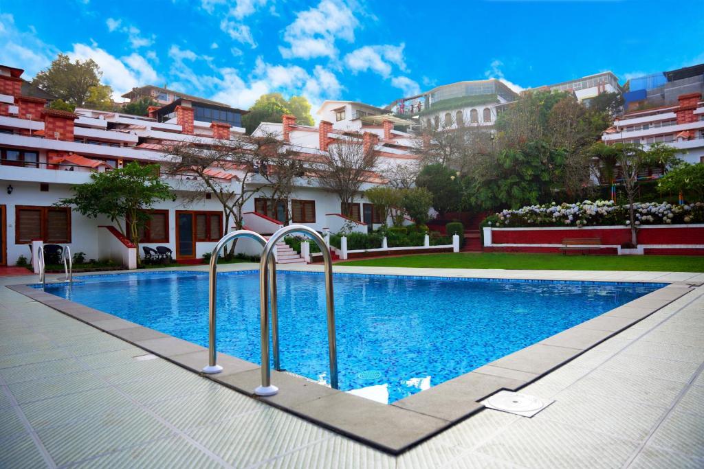 a swimming pool in front of a building at Kodai Resort Hotel, Kodaikanal in Kodaikānāl