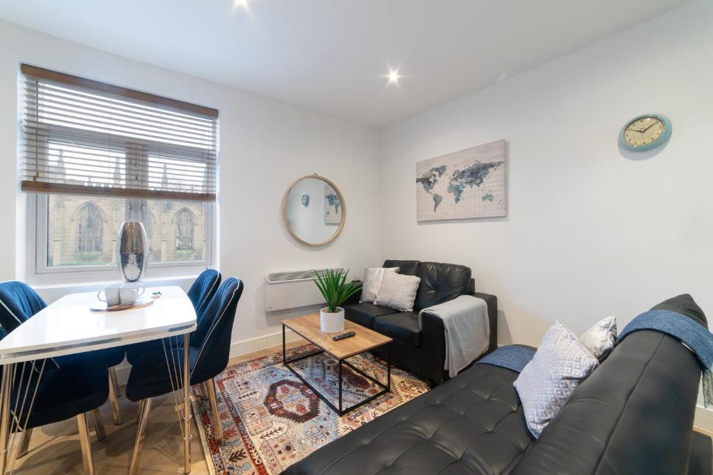 a living room with a couch and a table at Orange Rentals- Studio apartment in the city centre of Liverpool in Liverpool