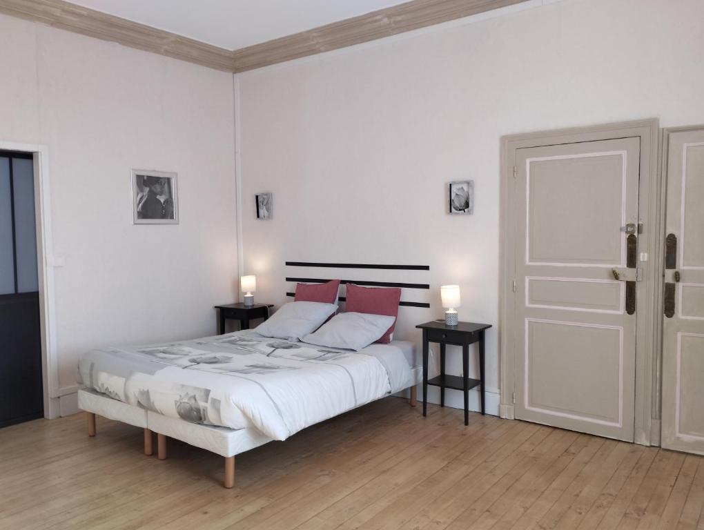 a white bedroom with a bed and two night stands at Villa du Cerf Thibault in Le Blanc