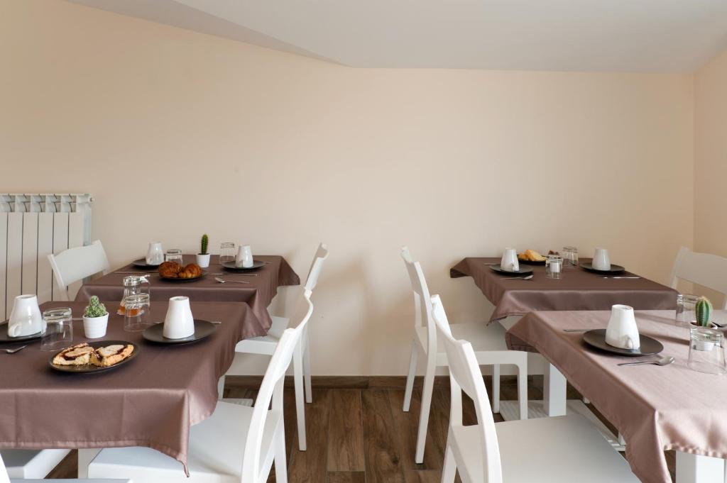 a dining room with brown tables and white chairs at B&B Raffaello a Mare in Montesilvano