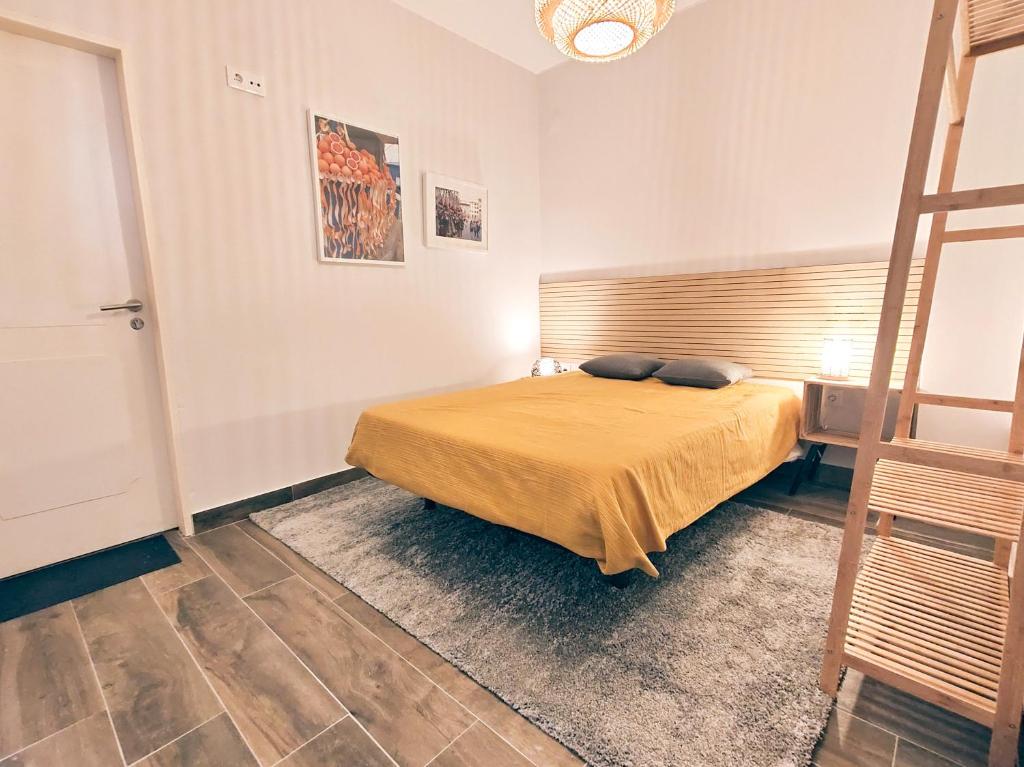 ein Schlafzimmer mit einem Bett mit gelber Tagesdecke in der Unterkunft Santa Cruz Ocean Apartment - II in Santa Cruz