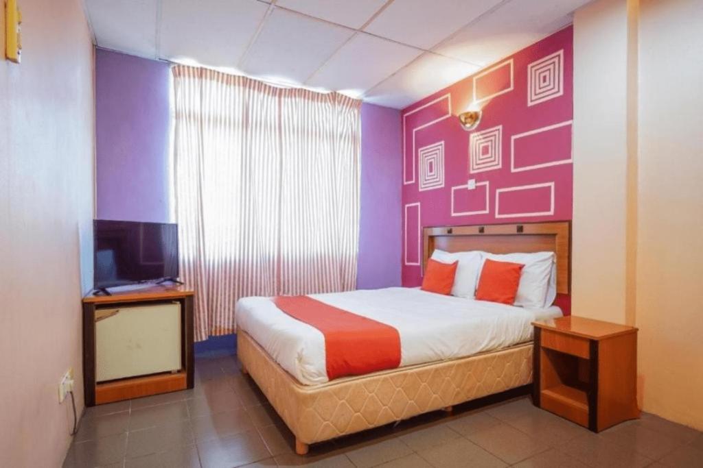 Postel nebo postele na pokoji v ubytování DJ Hotel Lumut