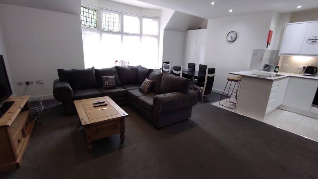 a living room with a couch and a table at Staines City Centre Apartments in Staines upon Thames