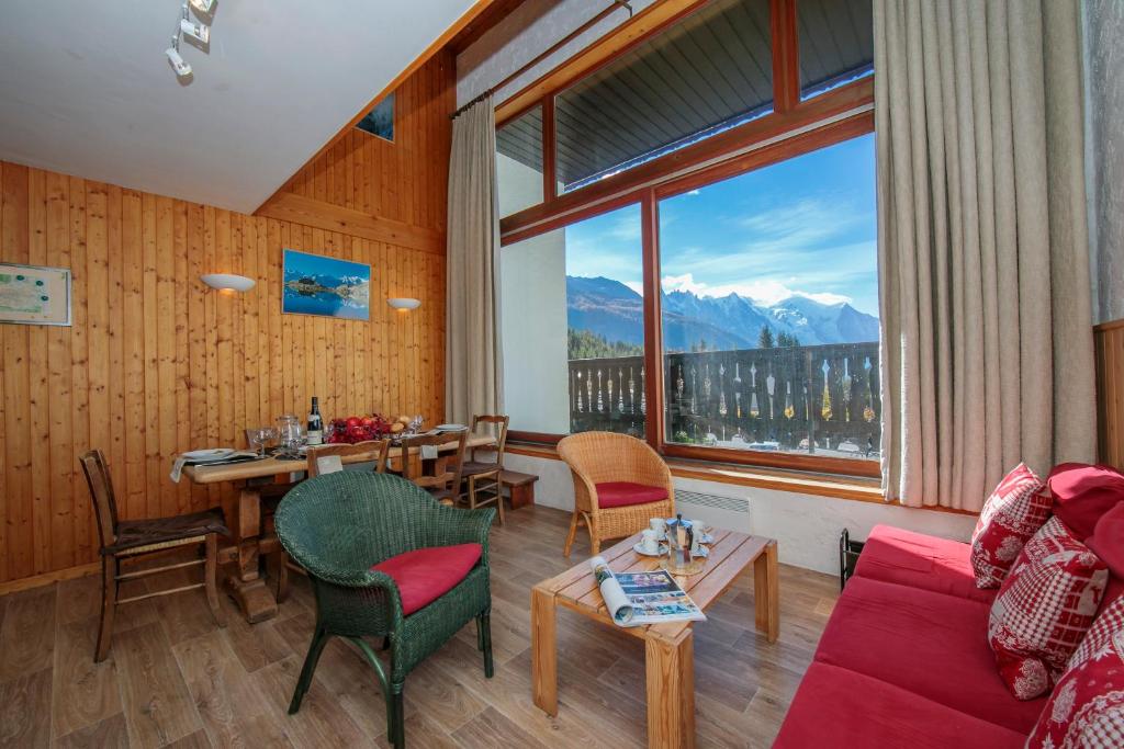 ein Wohnzimmer mit einem Tisch und einem großen Fenster in der Unterkunft Chalet Charpoua - Happy Rentals in Chamonix-Mont-Blanc
