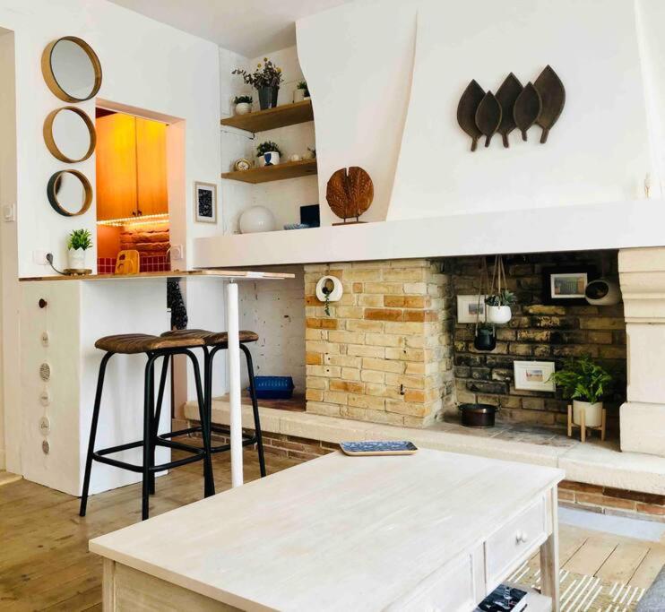 une cuisine avec une table et des chaises dans une pièce dans l'établissement Les Mouettes, à Trouville-sur-Mer