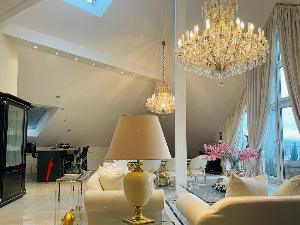 a living room with a couch and a chandelier at Penthouse Mülheim- Ruhr - Zentral - Edel - Luxus pur in Mülheim an der Ruhr