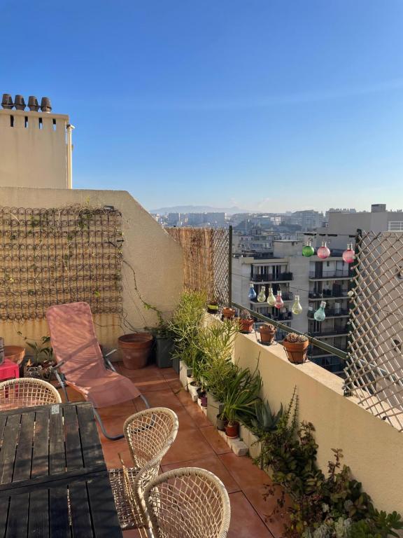 d'une terrasse avec des chaises et des plantes sur un balcon. dans l'établissement Appart 60 m2 avec terrasse 35m2 séjour sud et 2 vraies chambres gare Saint-Charles, à Marseille