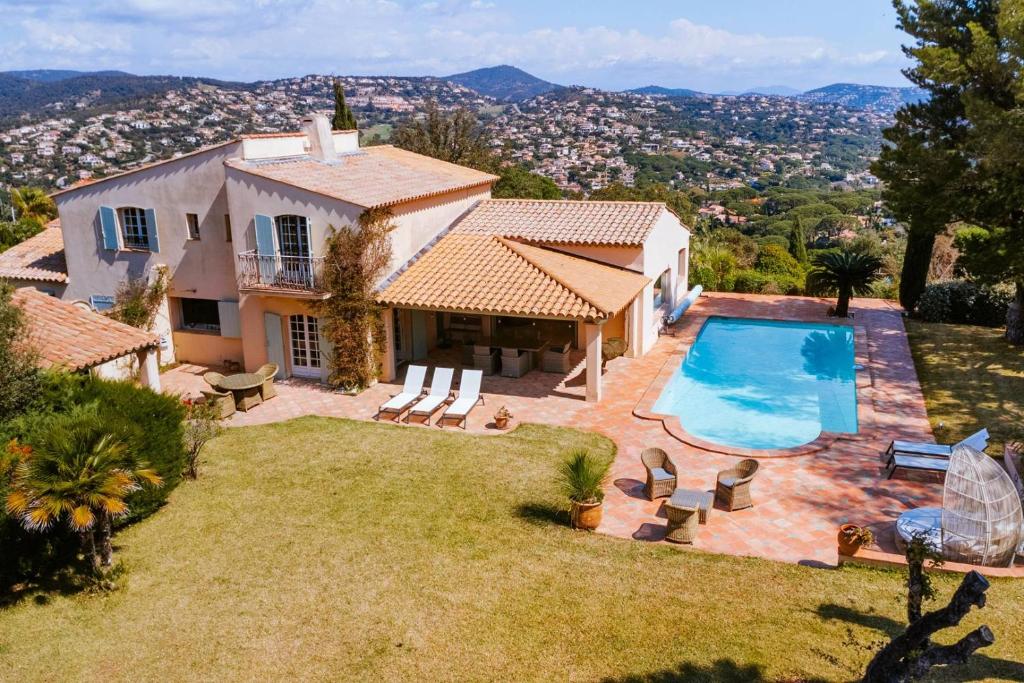 een luchtzicht op een huis met een zwembad bij La Villa des Cades avec vue mer et piscine privée sur les hauteurs de Stre-Maxime in La Nartelle