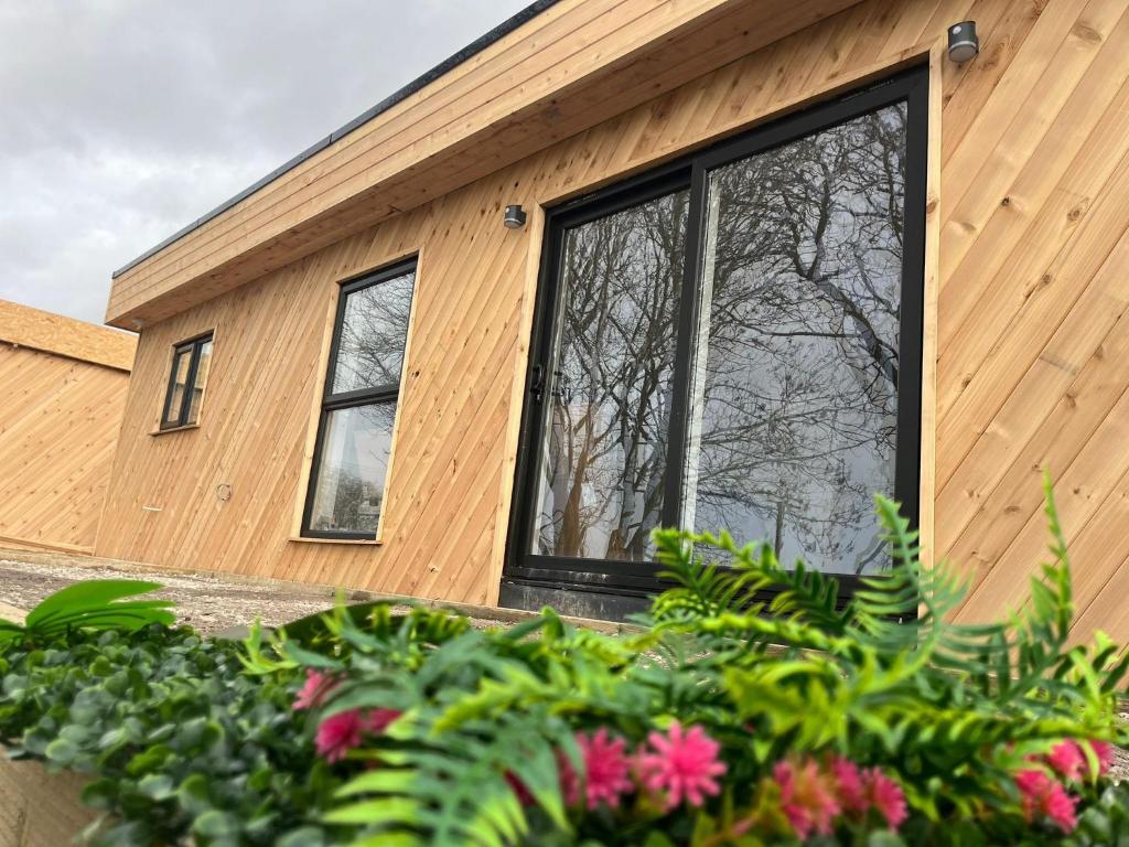 a house with a large window on the side of it at North Wales Eco Lodges in Ruthin
