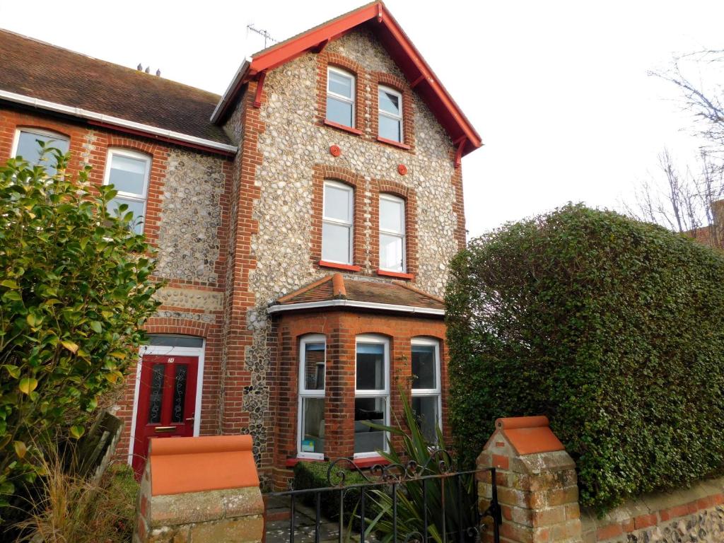 a brick house with a red door at Corner House in Sheringham